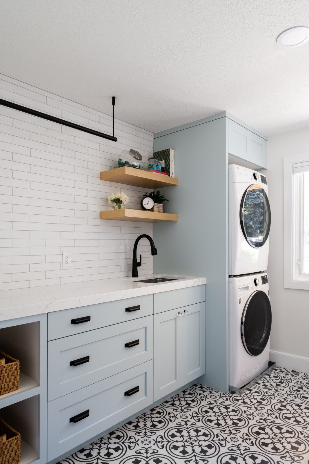 Custom laundry room with stacked washer-dryer and floating shelves