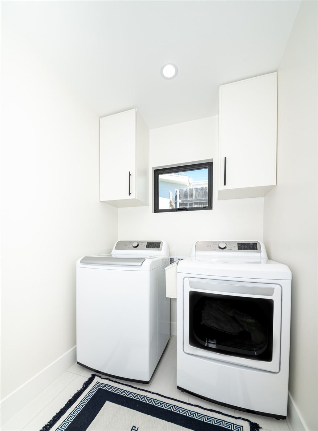 Bright laundry room with white cabinets