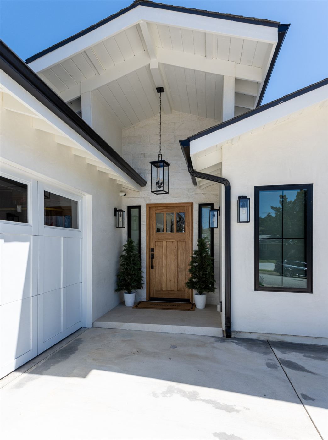 Entrance with wooden front door and black sloped roof