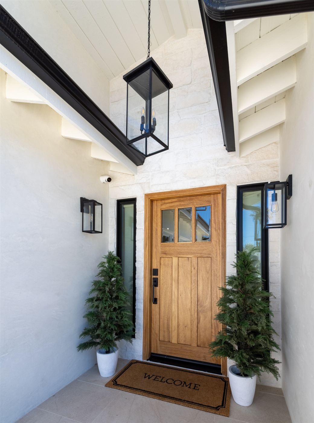 Modern home entrance with white brick exterior and wooden front door