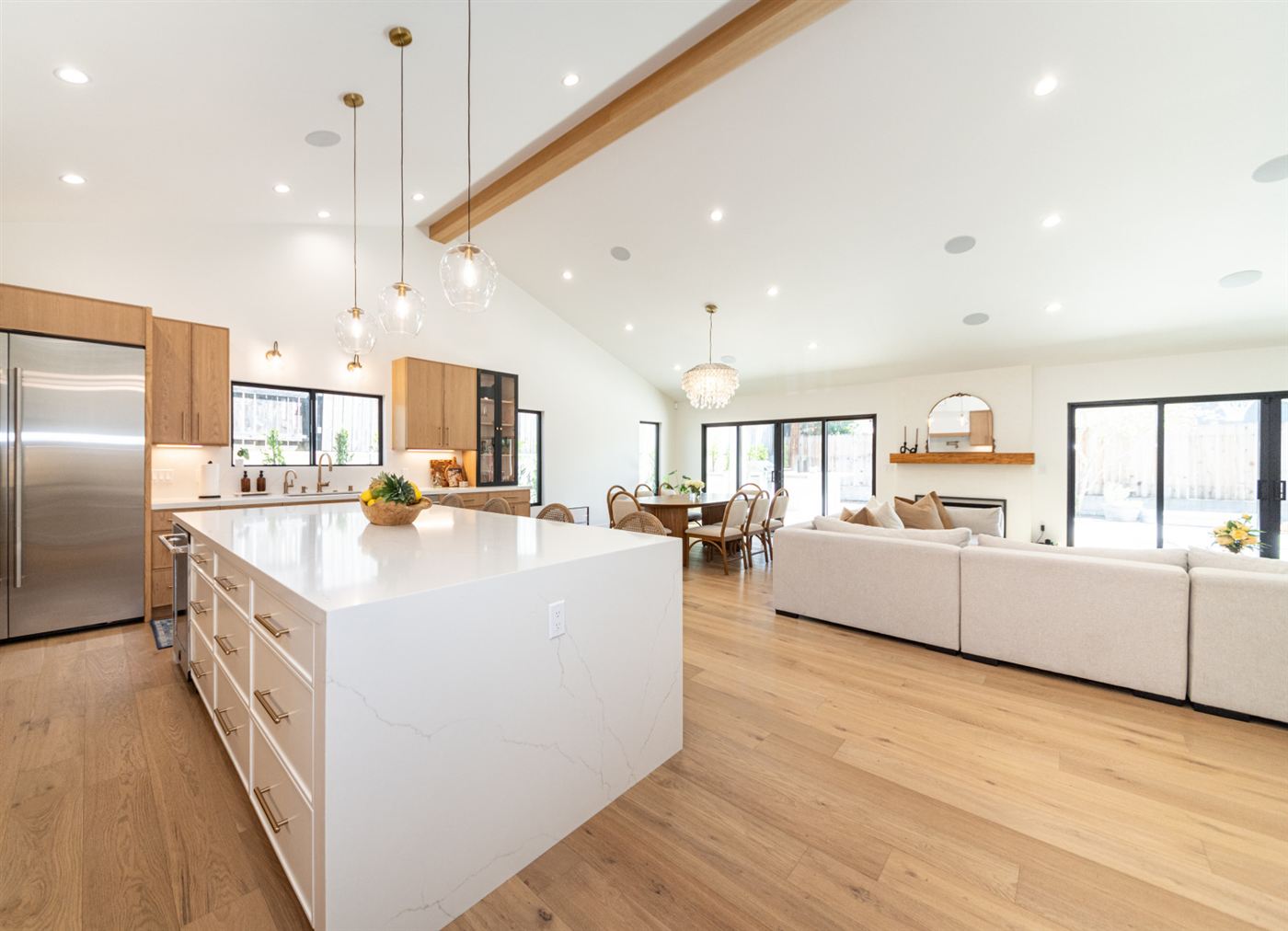 White waterfall island with warm wood cabinetry