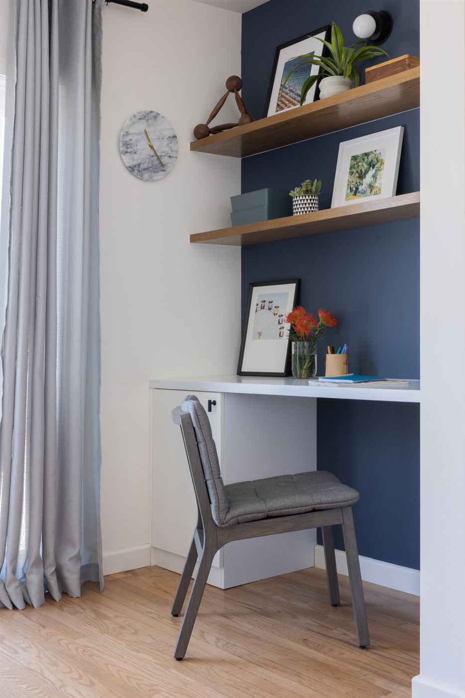 Home office nook with deep navy blue accent wall