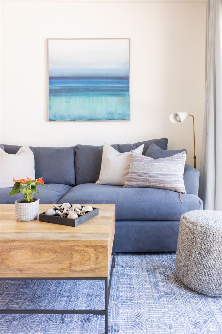 Living room with deep blue sofa and light wood coffee table