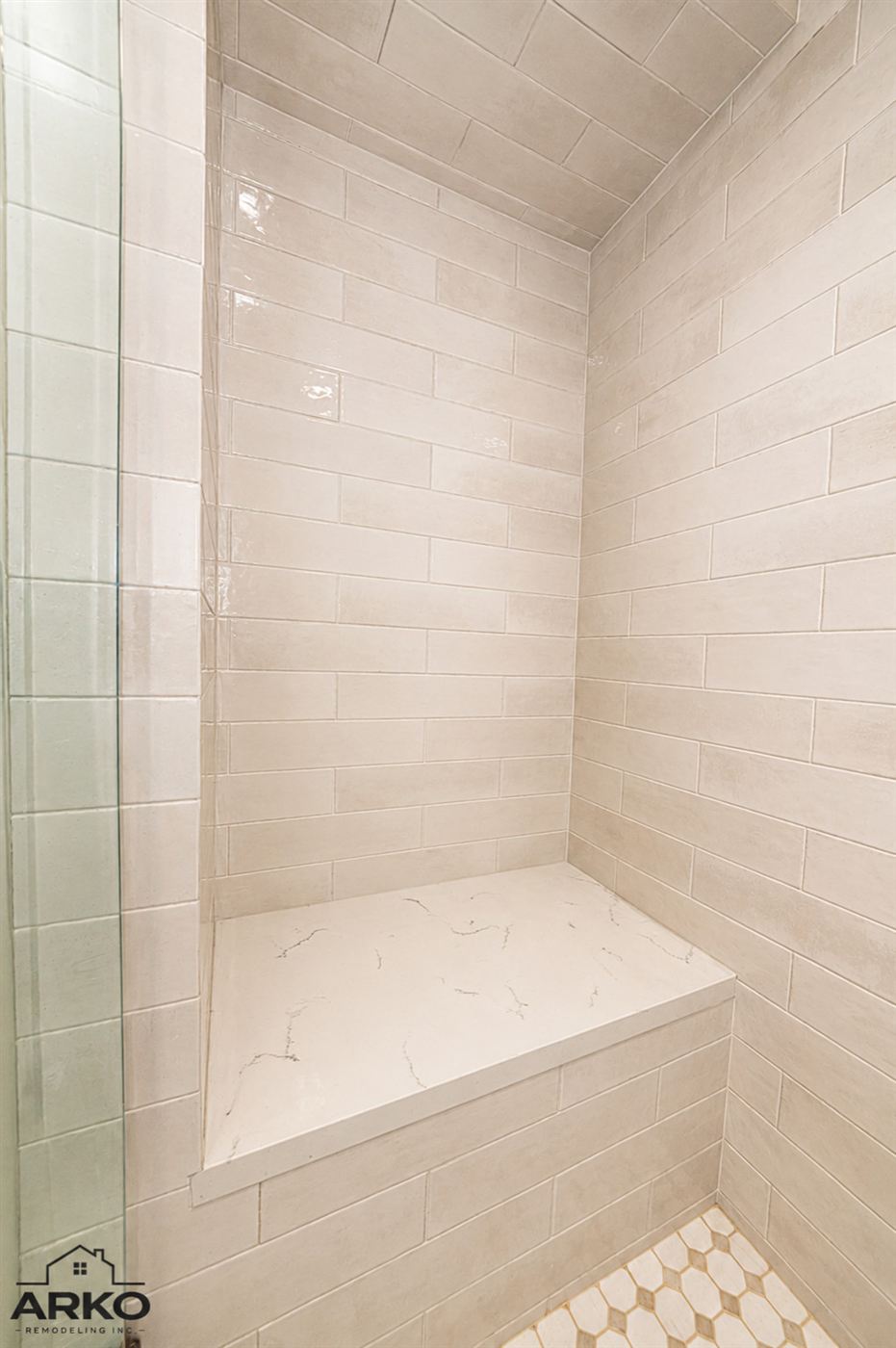 Walk-in shower with large-format tile and built-in stone bench