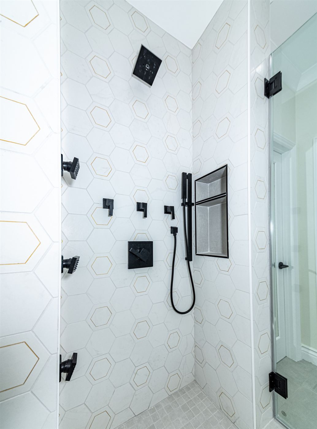 Shower with white hexagon tile and matte black fixtures